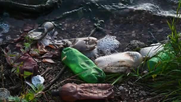 Plastové láhve a další nerozložitelný odpad na pobřeží rybníka. — Stock video