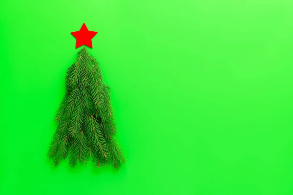 Árvore de Natal alternativa feita de ramos de abeto em um fundo verde. — Fotografia de Stock