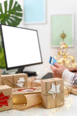 İnternetten Noel alışverişi. Tanımlanamayan Adam Eller kredi kartı tutuyor ve bilgisayar kullanarak hediyeler alıyor..