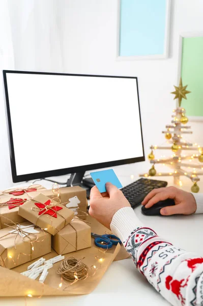 Compras de Natal online. Homem irreconhecível Mãos segurando presentes de compra de cartão de crédito usando um computador. — Fotografia de Stock