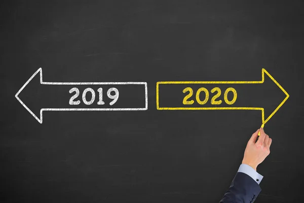 Human Hand Drawing Old Year New Year 2020 on Chalkboard Background