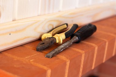 Oluşturma araçları. Pense ve keski kırmızı tuğla üzerinde