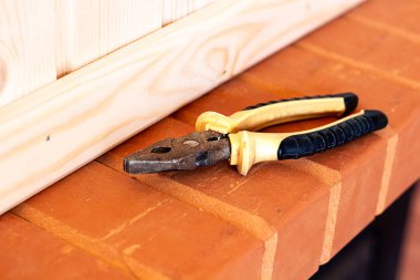 Oluşturma araçları. Pense ve keski kırmızı tuğla üzerinde