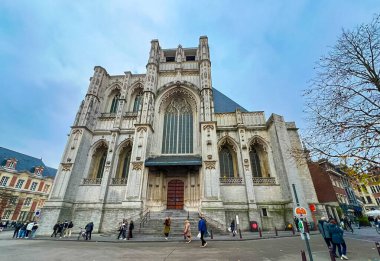 Leuven, Belçika - 1 Aralık 2023 Leuven 'in sakin boş meydanında yer alan güzel bir gotik kilise. Uzun kemerler ve karmaşık pencereler zarif mimari ayrıntıları gösteriyor..