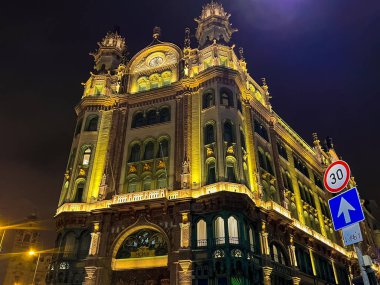 Budapeşte, Macaristan 11 Aralık 2023: Parisi Udvar Oteli 'nin eski binası, Paris Geçidi. Budapeşte 'de saatli bir bina. Gece yarısı, sarı ışıklarla aydınlatılmış bir bina.. 