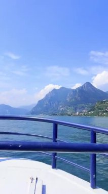 İtalya 'daki mavi gökyüzünü yansıtan sakin bir Iseo gölünün olduğu çarpıcı bir manzara. Yeşillik tarafından çerçevelenmiş görkemli dağlar uzaklardan yükselir. Huzurlu ve görkemli bir manzara yaratır..