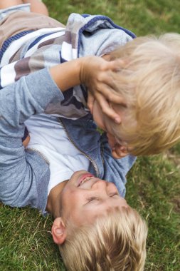 İki kardeş yeşil çimlerde oynarken eğleniyor..