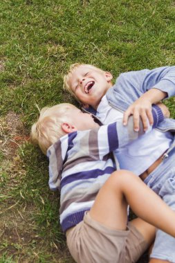 İki kardeş yeşil çimlerde oynarken eğleniyor..