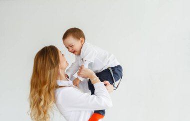 Küçük tatlı bir oğlu olan genç bir anne, parlak, rahat bir oturma odasında eğleniyor.