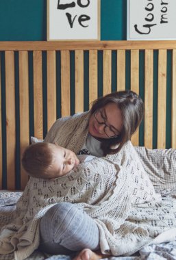 Anne ve çocuk yatak odasında, yatağın altında eğleniyor.