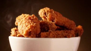 Döndürme kova kızarmış kentucky fried chicken tam dumanlı kahverengi zemin üzerine.