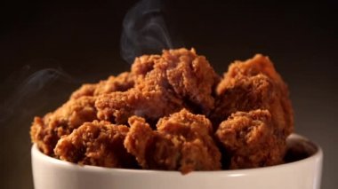 Döndürme kova kızarmış kentucky fried chicken tam dumanlı kahverengi zemin üzerine.