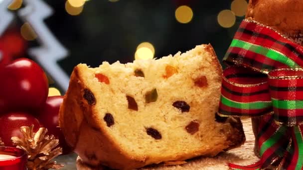 Köstliche Panettone Scheibe Mit Kandierten Früchten Mit Blinkender Verschwommener Weihnachtsbeleuchtung — Stockvideo