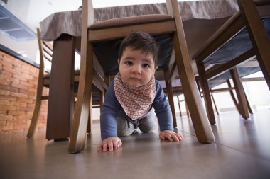 güzel bebek çocuk masanın altında.