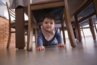 güzel bebek çocuk masanın altında.