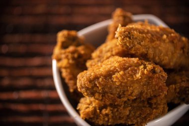 Dumanlı kahverengi zemin üzerine kızarmış kentucky fried chicken dolu kova. Seçici odak.