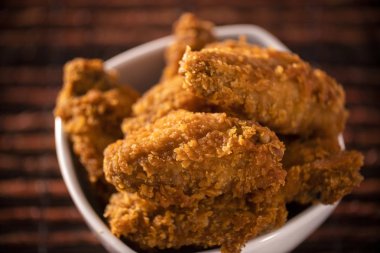 Dumanlı kahverengi zemin üzerine kızarmış kentucky fried chicken dolu kova. Seçici odak.
