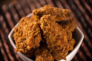 Dumanlı kahverengi zemin üzerine kızarmış kentucky fried chicken dolu kova. Seçici odak.
