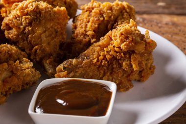 Kahverengi zemin üzerinde duman ve Barbekü soslu kızarmış kentucky fried chicken dolu kova. Seçici odak.