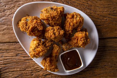 Kahverengi zemin üzerinde duman ve Barbekü soslu kızarmış kentucky fried chicken dolu kova. Seçici odak.