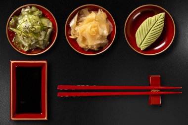 Sunomono, zencefil, wasabi, hashi ve siyah arka plan üzerine izole shoyu. üstten görünüm