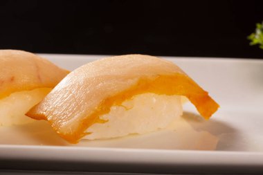 Siyah arka plan üzerine somon balıklı Nigiri Shiromi suşi.