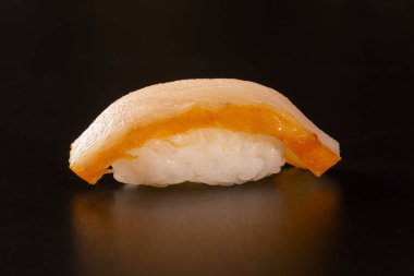 Siyah arka plan üzerine somon balıklı Nigiri Shiromi suşi.