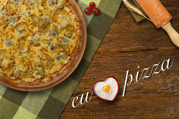 hot homemade brazilian pizza on wood table, top view. I love pizza written in Portuguese. Copy space