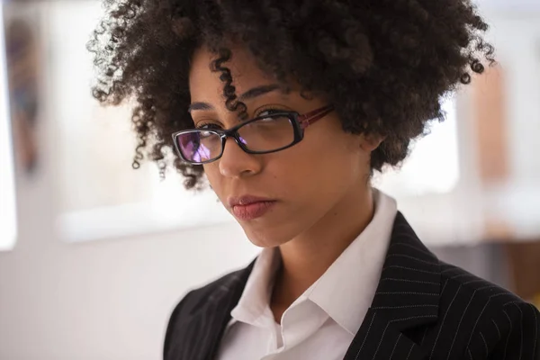 Close up portrait black business woman employee in glasses working in office with tablet looking at camera.