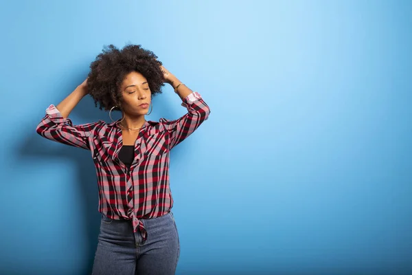 Retrato de una joven negra que ríe contra la pared azul — Foto de Stock