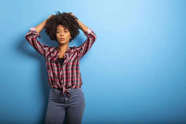 Retrato de una joven negra que ríe contra la pared azul — Foto de Stock