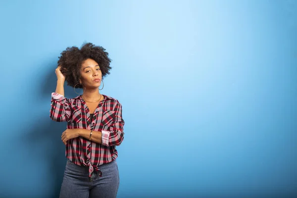 Retrato de una joven negra que ríe contra la pared azul - Imagem . — Foto de Stock