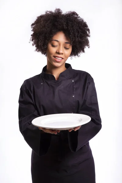 Concetto di cucina e cibo - chef, cuoca o panettiera africana sorridente con piatto vuoto . — Foto Stock