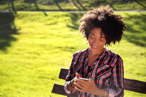 Retrato de una joven afroamericana escuchando música en un celular - Imagem . — Foto de Stock