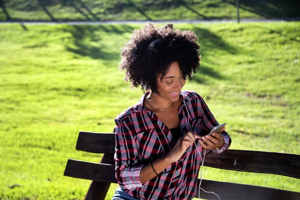 Retrato de una joven afroamericana escuchando música en un celular - Imagem . — Foto de Stock