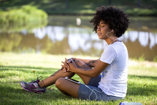 Potret seorang wanita Afrika-Amerika muda mendengarkan musik di ponsel — Stok Foto