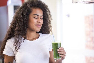 Genç Afrikalı kadın kilo kaybı ve detoks için sağlıklı vejetaryen smoothie 'den hoşlanıyor..