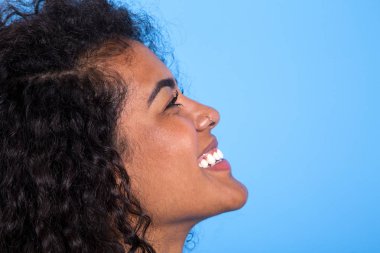 mavi arka planda güzel Afrikalı kadın güzellik yan görünümü - Imagem.