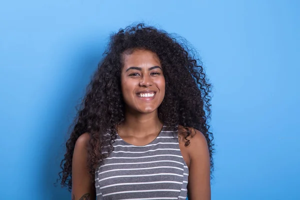 Portrait of smiling black woman with afro hairstyle on blue background - Imagem.