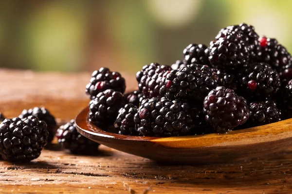 ahşap masada ahşap kase taze böğürtlen. Seçici odaklama