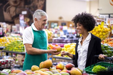 Manav ile Afrika Müşteri, mango tutan.