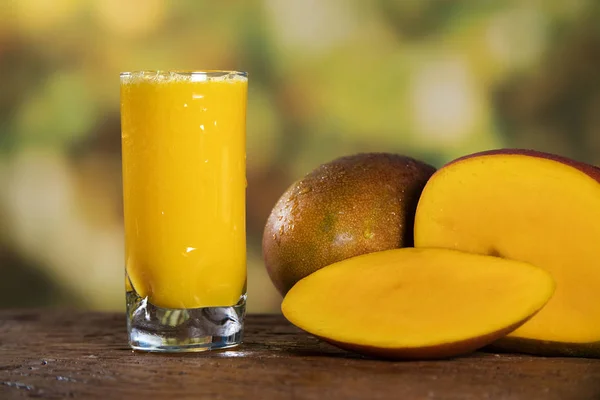 Fresh mango juice and mango fruit with a natural backdrop.