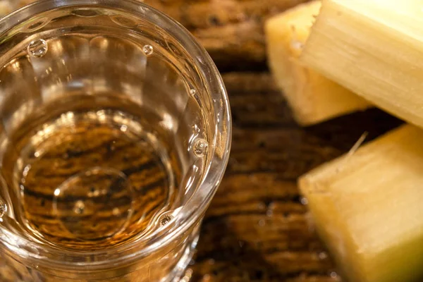Два стакана бразильского золота качака с сахаром и сахарным тростником изолированы на деревенском деревянном фоне . — стоковое фото