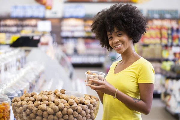 Adult kvinnlig afrikansk kund välja nötter i snabbköpet — Stockfoto