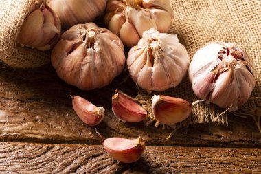 Sarımsak yakın, Sarımsak ampul, ahşap arka plan üzerinde jüt çuval Sarımsak karanfil