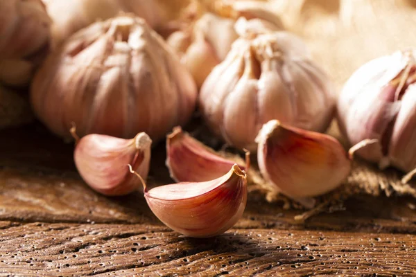 Garlic close up, Garlic bulb, Garlic cloves in jute sack on wooden background