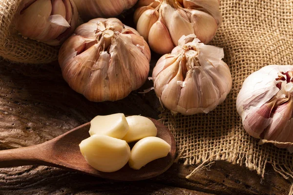 Garlic close up, Garlic bulb, Garlic cloves in jute sack on wooden background