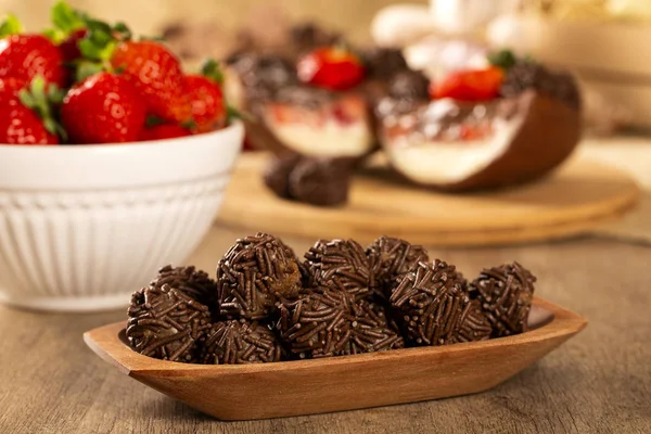 Trufa brasileña de chocolate bonbon brigadeiro sobre mesa de madera con fresa y fondo de Pascua — Foto de Stock