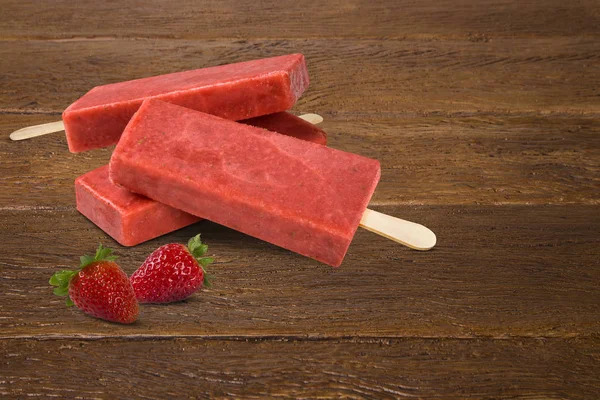 Stick ice cream Strawberry flavor isolated on wood background. Mexican Pallets.