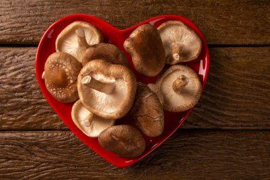 ahşap arka plan üzerinde kırmızı kalp kase mantar. En İyi Görüntü.